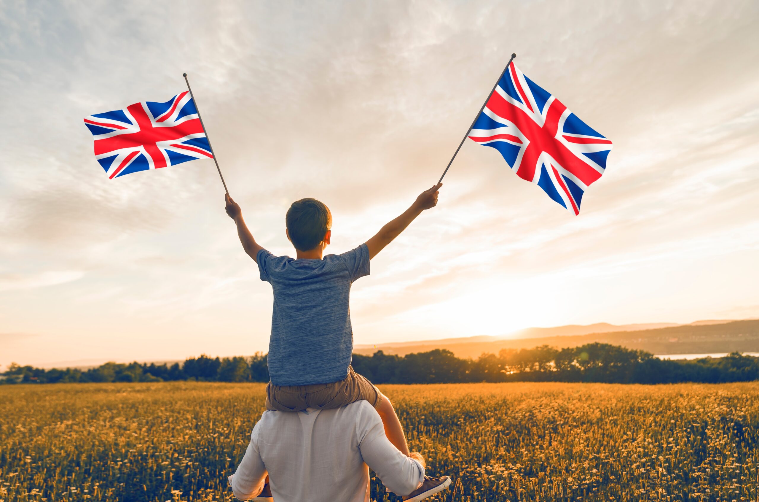A Patriotic Father And Child Waving England Union Flag In Field