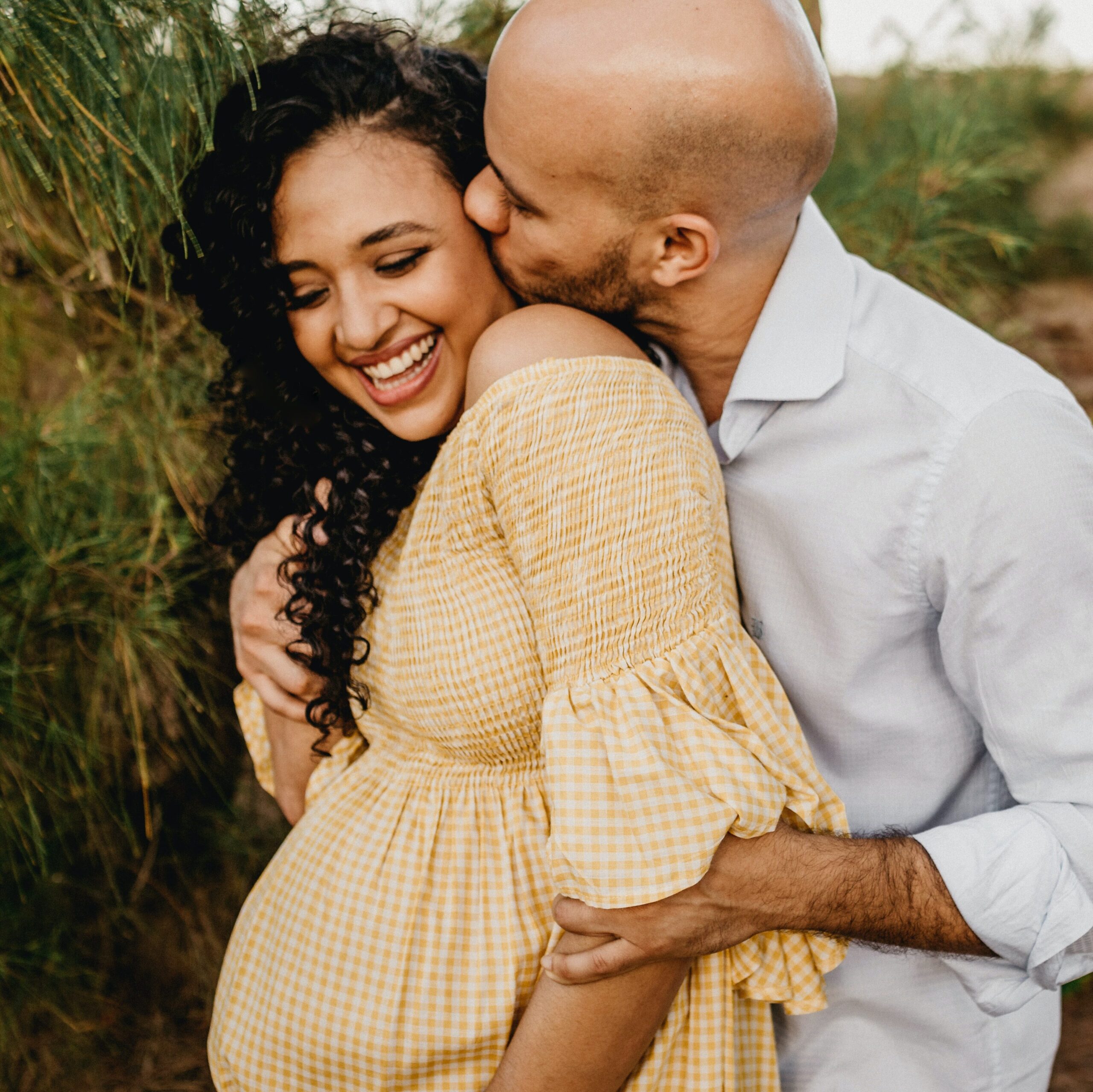 man cuddling pregnant wife